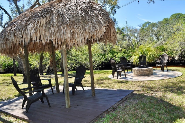 view of community with a fire pit, a lawn, and a wooden deck