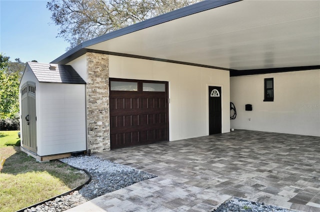 exterior space featuring stone siding, decorative driveway, and stucco siding