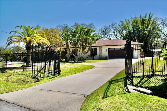 view of front of home with driveway, an attached garage, a gate, fence, and a front yard