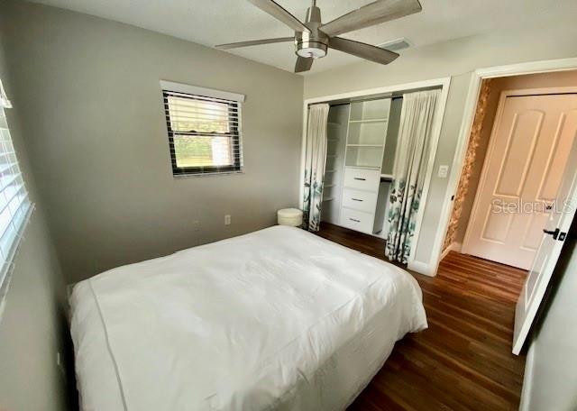 bedroom featuring ceiling fan, dark wood finished floors, and a closet