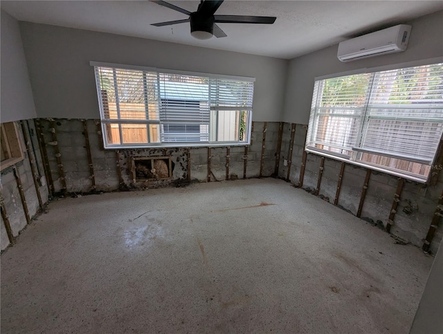 empty room featuring a ceiling fan, a wealth of natural light, and a wall unit AC