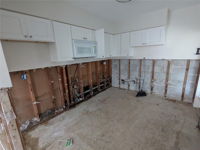 kitchen with white microwave and white cabinets