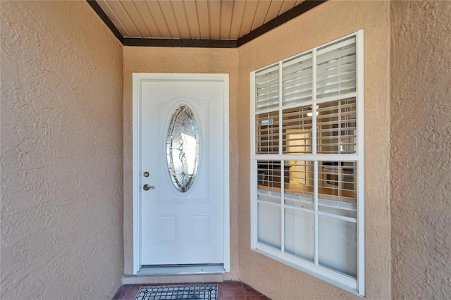 doorway to property featuring stucco siding