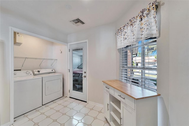 laundry area with laundry area, separate washer and dryer, light floors, and visible vents