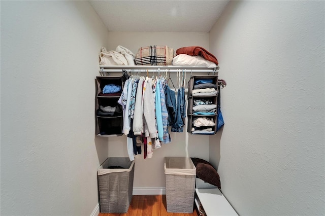 walk in closet with wood finished floors