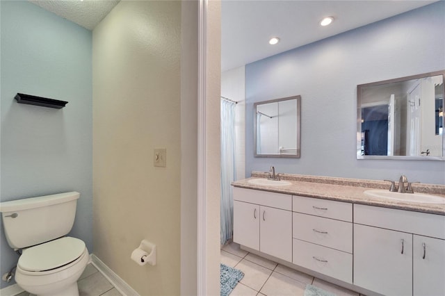 bathroom featuring double vanity, a sink, toilet, and tile patterned floors