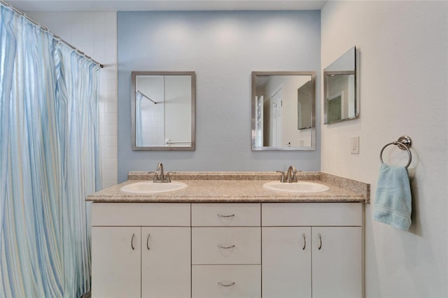 bathroom featuring double vanity, a shower with curtain, and a sink