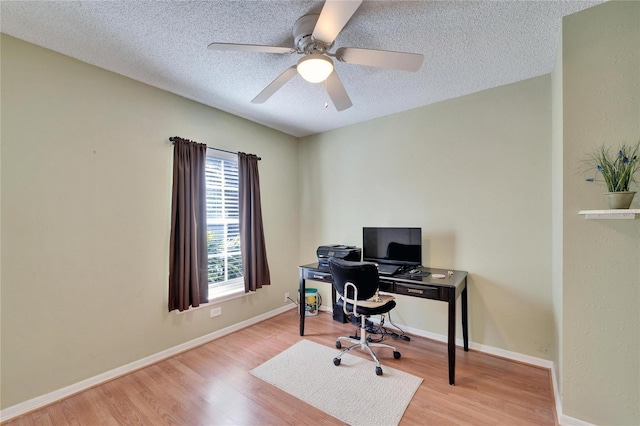 home office featuring ceiling fan, a textured ceiling, baseboards, and wood finished floors