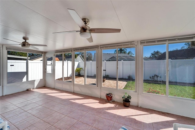 unfurnished sunroom featuring a ceiling fan