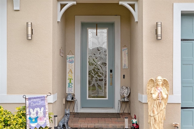 doorway to property with a garage and stucco siding