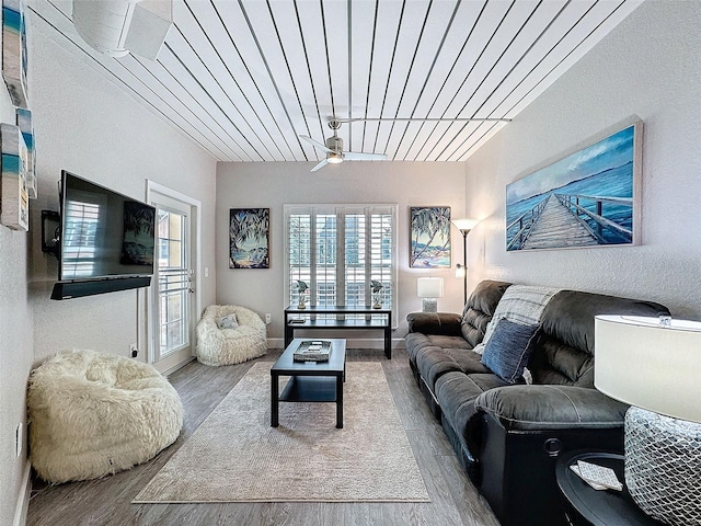 living area with ceiling fan, baseboards, and wood finished floors