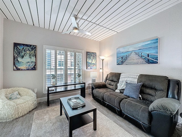 living area featuring wooden ceiling, ceiling fan, baseboards, and wood finished floors