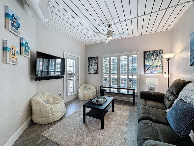 living room featuring ceiling fan, baseboards, and wood finished floors