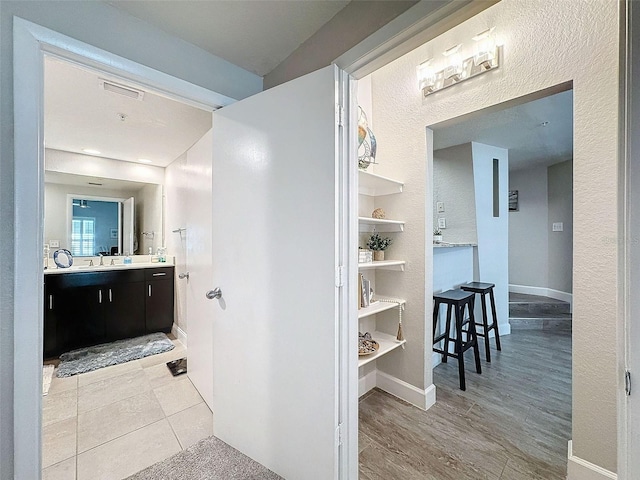 bathroom with baseboards, visible vents, a closet, and vanity