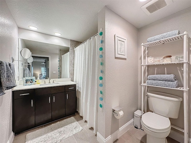 bathroom with visible vents, a textured wall, toilet, a textured ceiling, and vanity