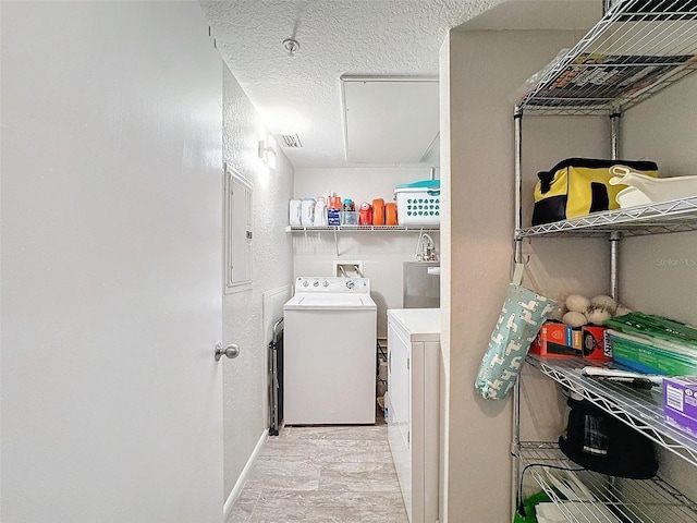 washroom featuring laundry area, visible vents, baseboards, a textured ceiling, and separate washer and dryer