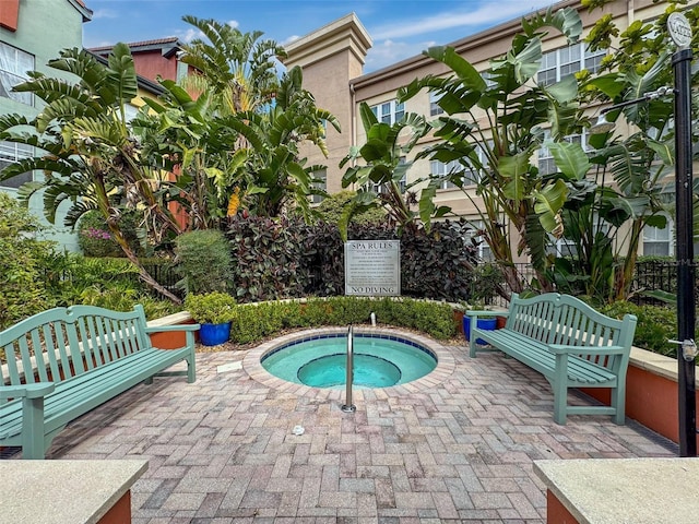 view of swimming pool featuring a patio and a hot tub