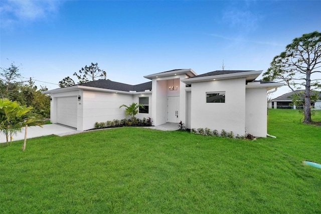 view of front of home featuring a garage, driveway, a front lawn, and stucco siding