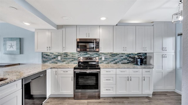 kitchen featuring light stone countertops, tasteful backsplash, appliances with stainless steel finishes, and light wood-style floors