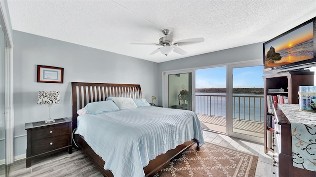 bedroom featuring access to exterior, a textured ceiling, light wood finished floors, and a ceiling fan