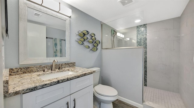 full bath featuring toilet, visible vents, walk in shower, and vanity