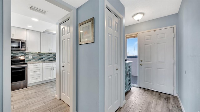 interior space featuring wood finish floors, visible vents, and baseboards