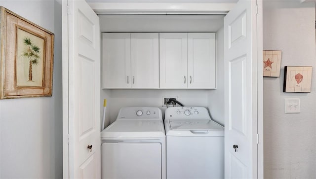 clothes washing area featuring cabinet space and washing machine and clothes dryer