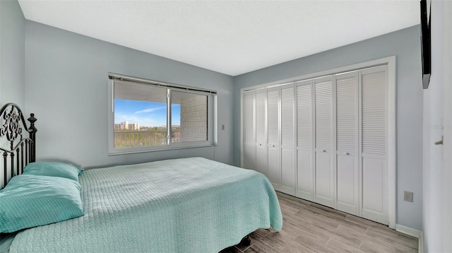 bedroom featuring light wood finished floors, a closet, and baseboards