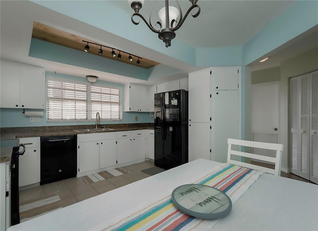 kitchen featuring white cabinets, hanging light fixtures, black appliances, a sink, and light tile patterned flooring