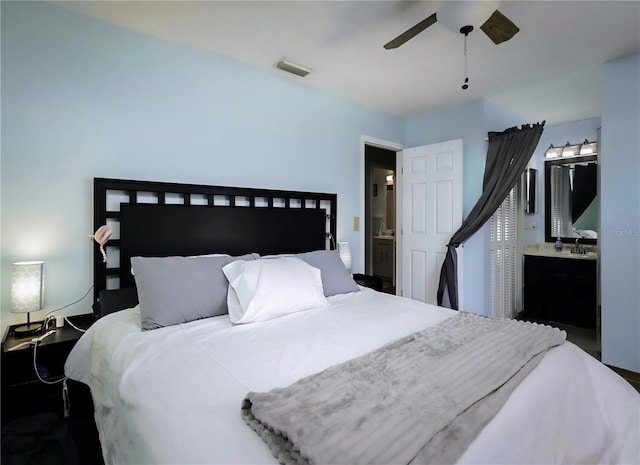 bedroom with ensuite bath, visible vents, and a ceiling fan