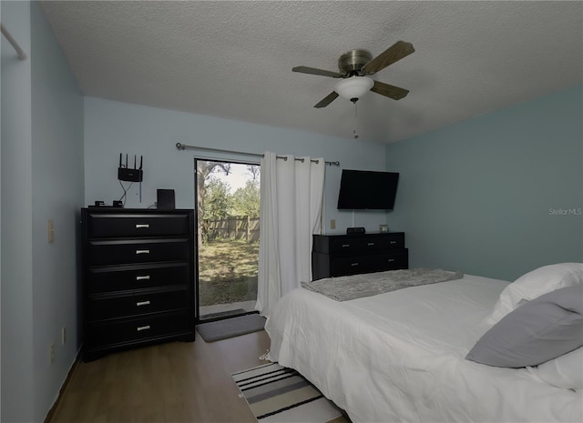 bedroom featuring a ceiling fan, access to outside, a textured ceiling, and wood finished floors