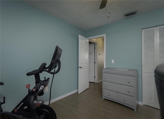 exercise area featuring baseboards, a ceiling fan, visible vents, and light wood-style floors