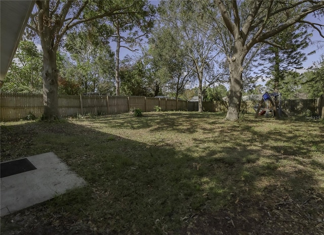 view of yard featuring a fenced backyard and a playground