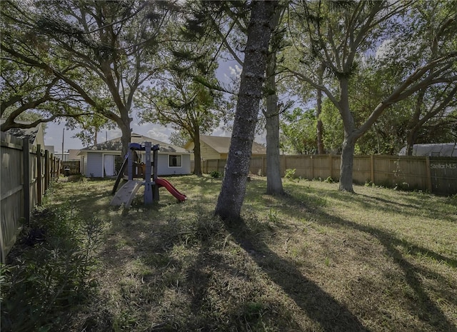 view of yard featuring a playground and a fenced backyard