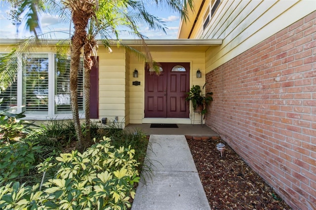 view of exterior entry with brick siding