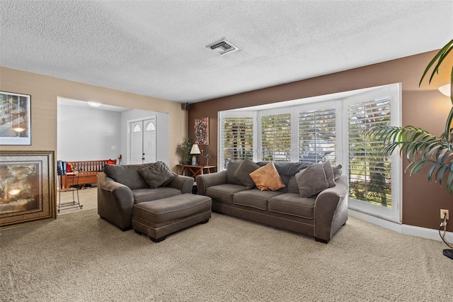 carpeted living room featuring a healthy amount of sunlight, visible vents, a fireplace, and a textured ceiling