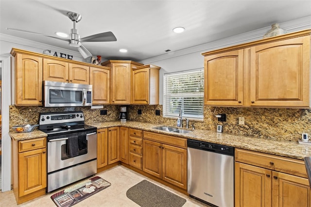 kitchen with ornamental molding, stainless steel appliances, light stone counters, and a sink