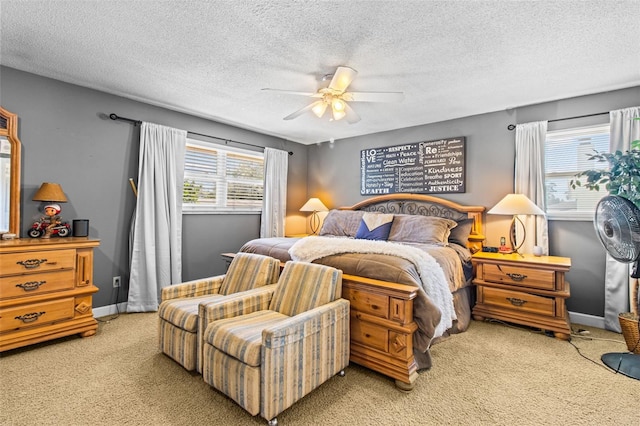 bedroom with a ceiling fan, light colored carpet, a textured ceiling, and baseboards