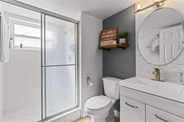 bathroom featuring toilet, a shower stall, vanity, and decorative backsplash