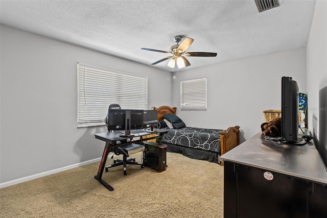 carpeted bedroom featuring a ceiling fan, baseboards, visible vents, and a textured ceiling