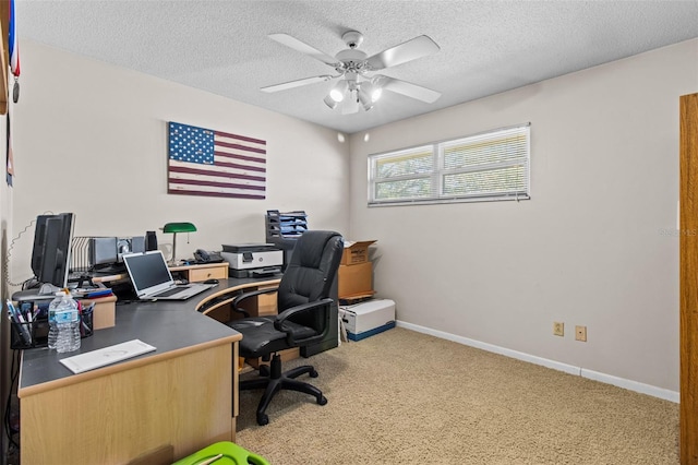 home office with a ceiling fan, light colored carpet, a textured ceiling, and baseboards