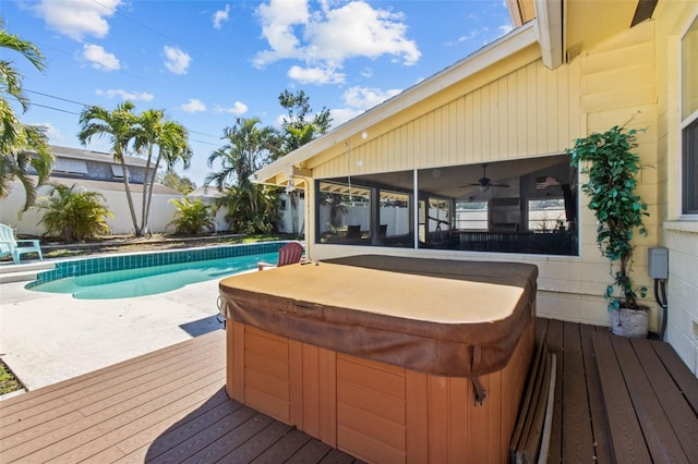 wooden terrace featuring fence, a sunroom, and a hot tub