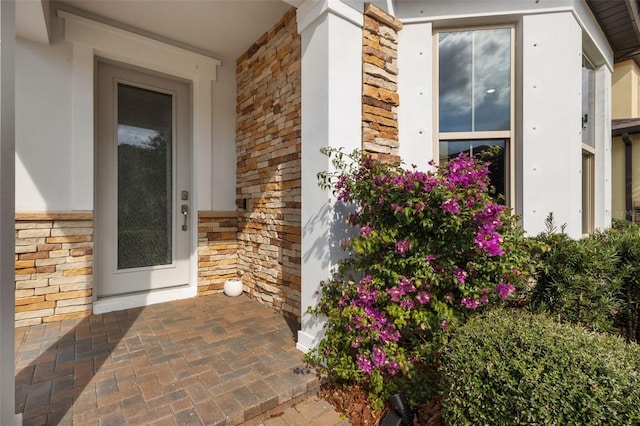 doorway to property with stone siding and brick siding