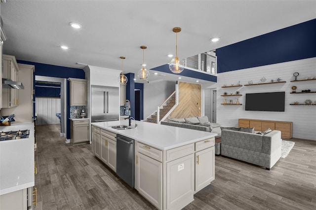 kitchen featuring open floor plan, light countertops, stainless steel dishwasher, and hanging light fixtures