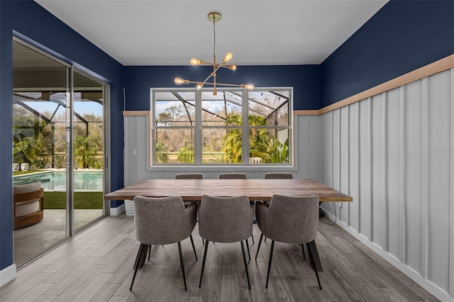 dining room with wood finished floors and a notable chandelier