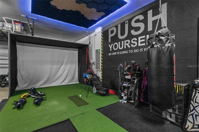 playroom with golf simulator and concrete block wall