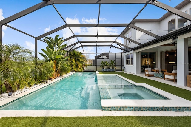 pool with a lanai, an in ground hot tub, and a patio