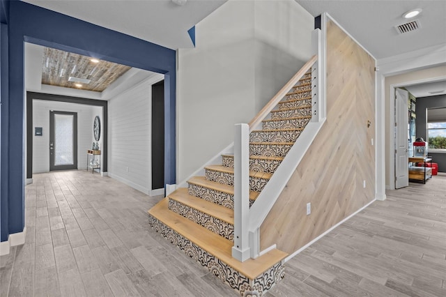 stairs featuring visible vents, baseboards, and wood finished floors