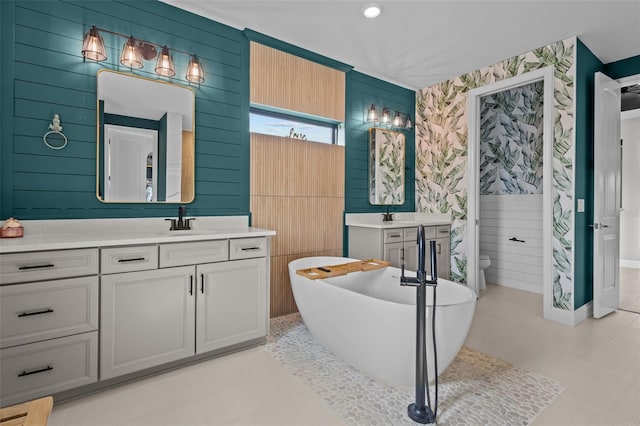 full bath with a soaking tub, vanity, and toilet