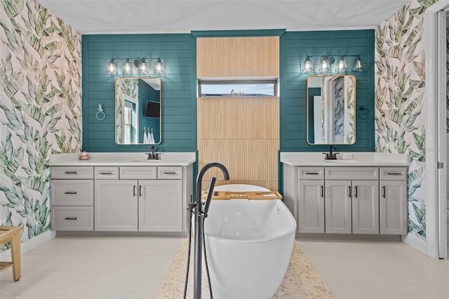 bathroom featuring a freestanding tub, two vanities, and a sink